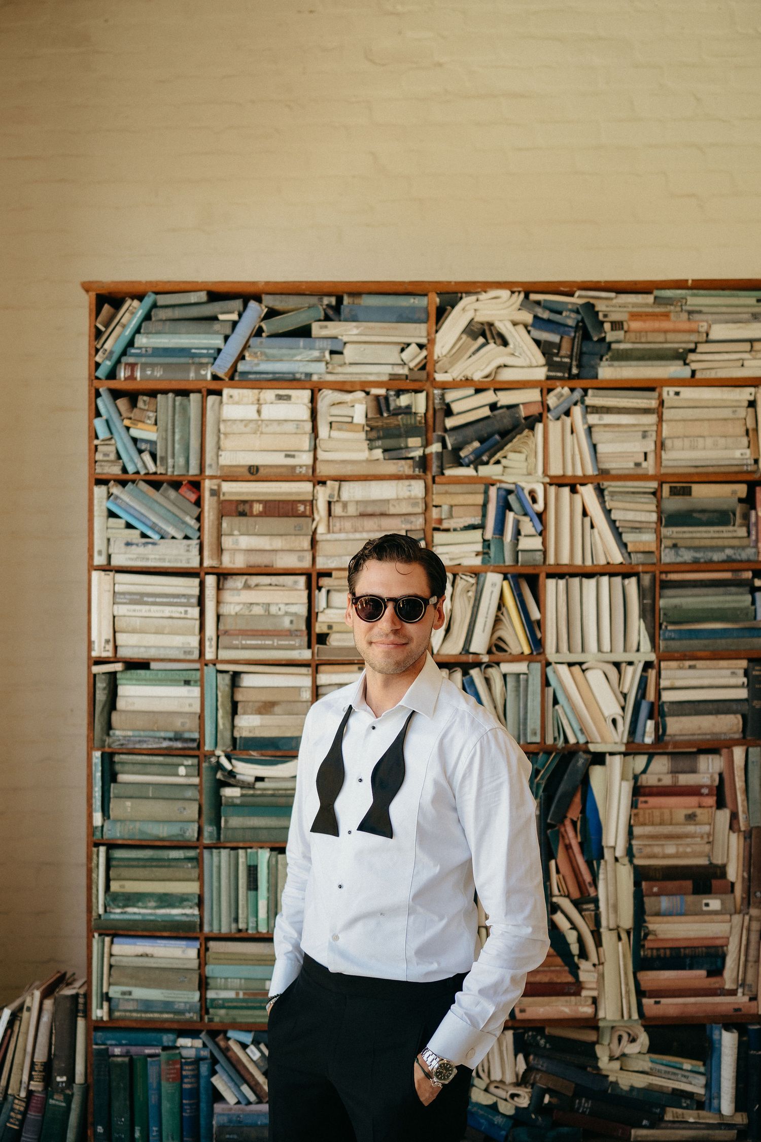 A series of photos showing someone in formal attire seated in front of wall-to-wall bookshelves.