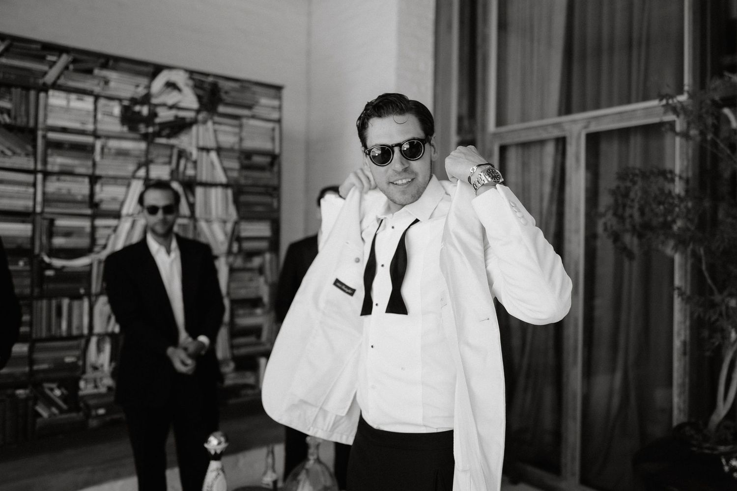 A black and white photo collage showing people in formal attire at what appears to be a social gathering or event.