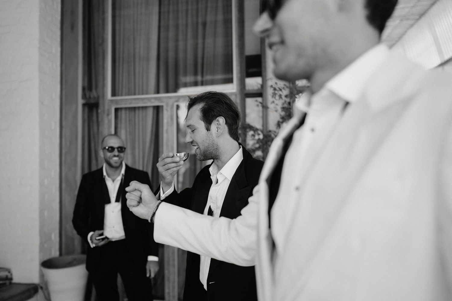Wedding guests dance and celebrate together on a dance floor at an indoor reception venue.
