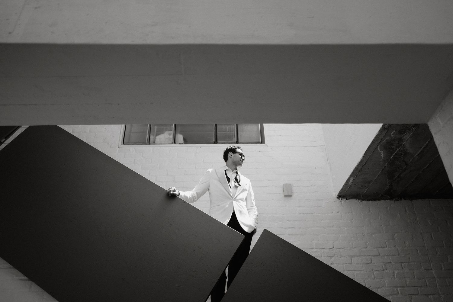 A black and white photo montage shows a series of architectural details and interior spaces in dramatic lighting.