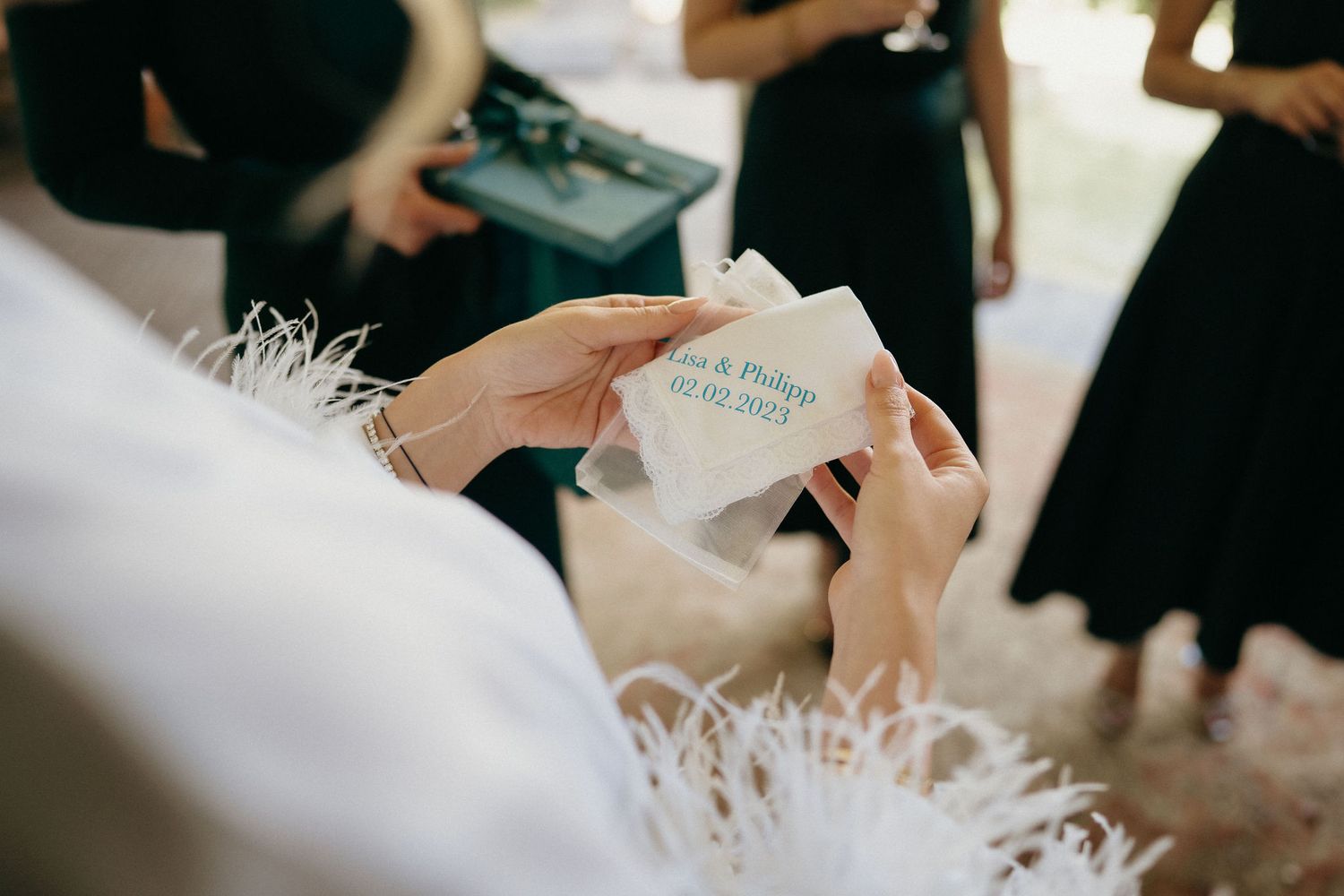 A person's hands carefully sign documents on a white desk with a pen during a formal ceremony or meeting.