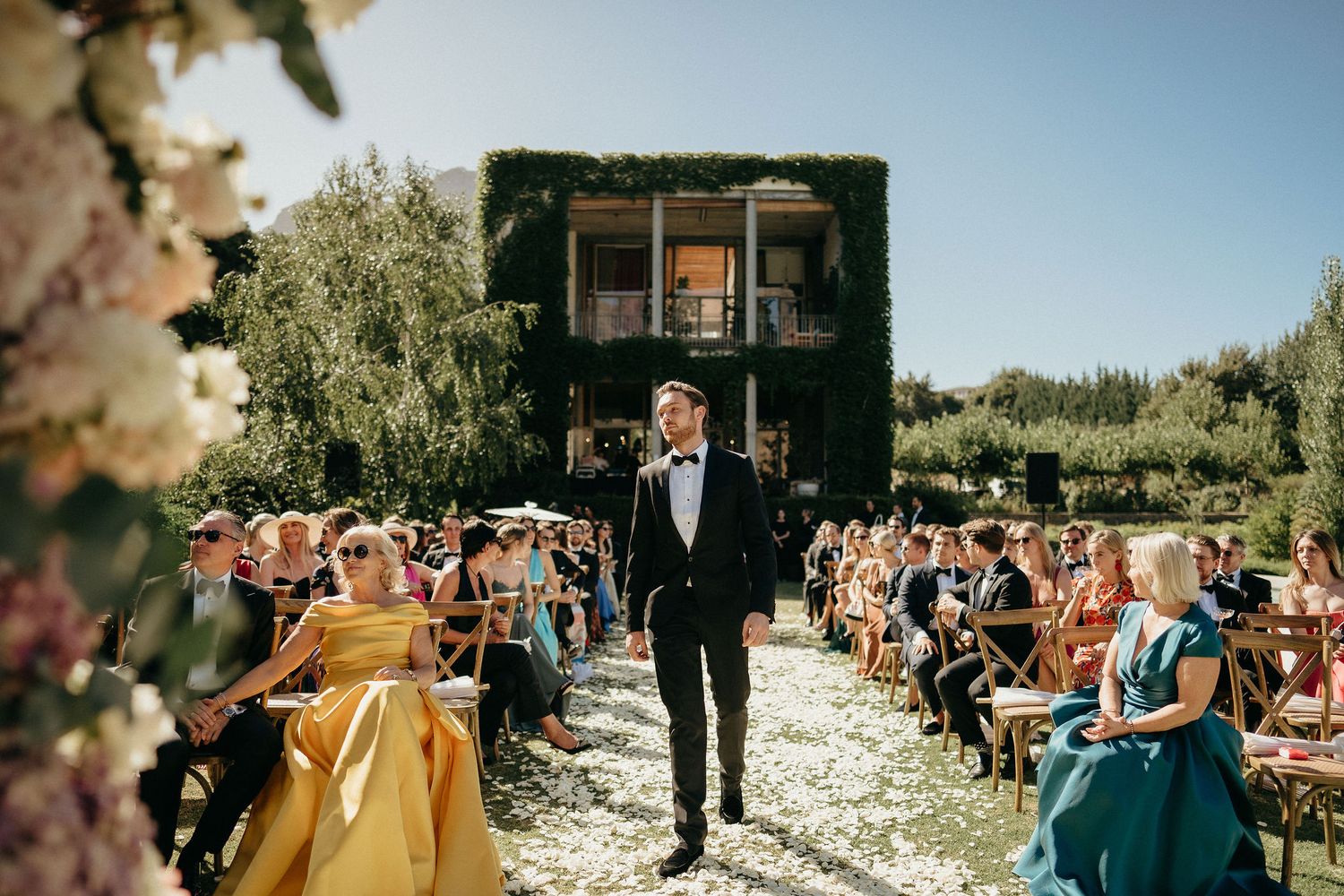 A collection of outdoor wedding ceremony moments with guests and decor on a sunny day.