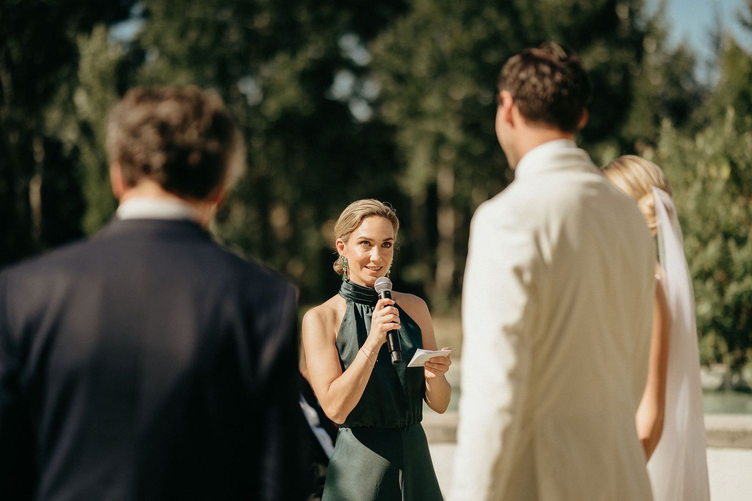 A wedding ceremony in a sunlit garden setting with guests gathered around during an intimate outdoor celebration.