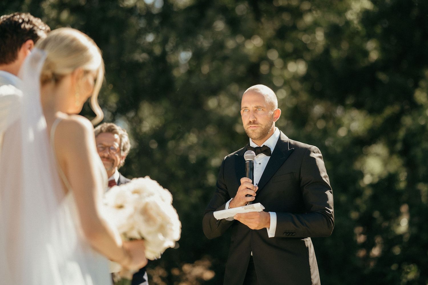 Wedding guests enjoy a slice of cake during an elegant outdoor reception celebration.