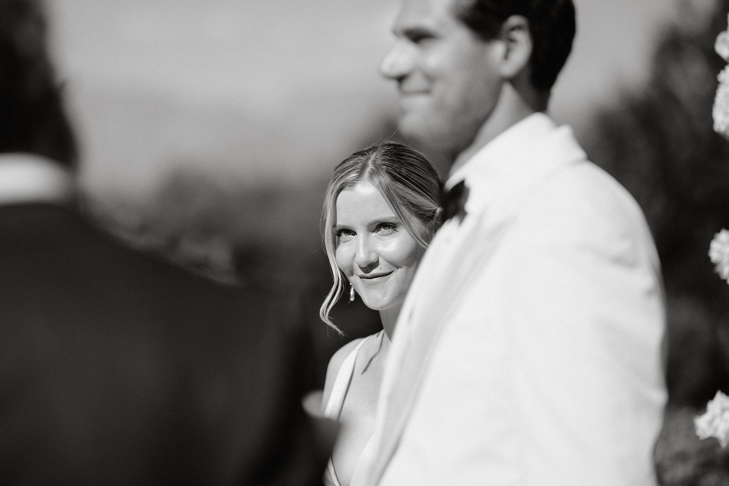 A black and white collage of wedding moments showing people in formal attire and celebratory expressions.