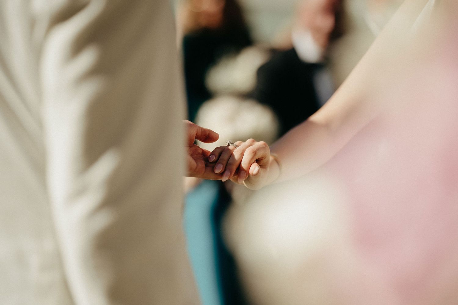 Bride and groom hold hands during intimate wedding ceremony moment.