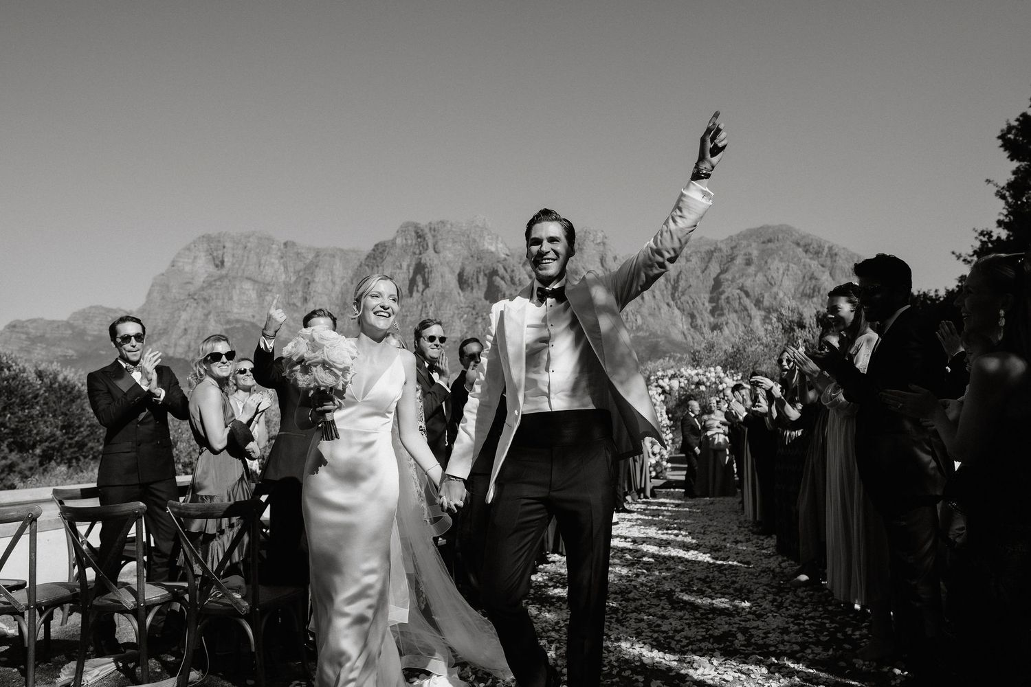 A black and white photo strip showing multiple frames of a couple posing together in an outdoor mountain setting.