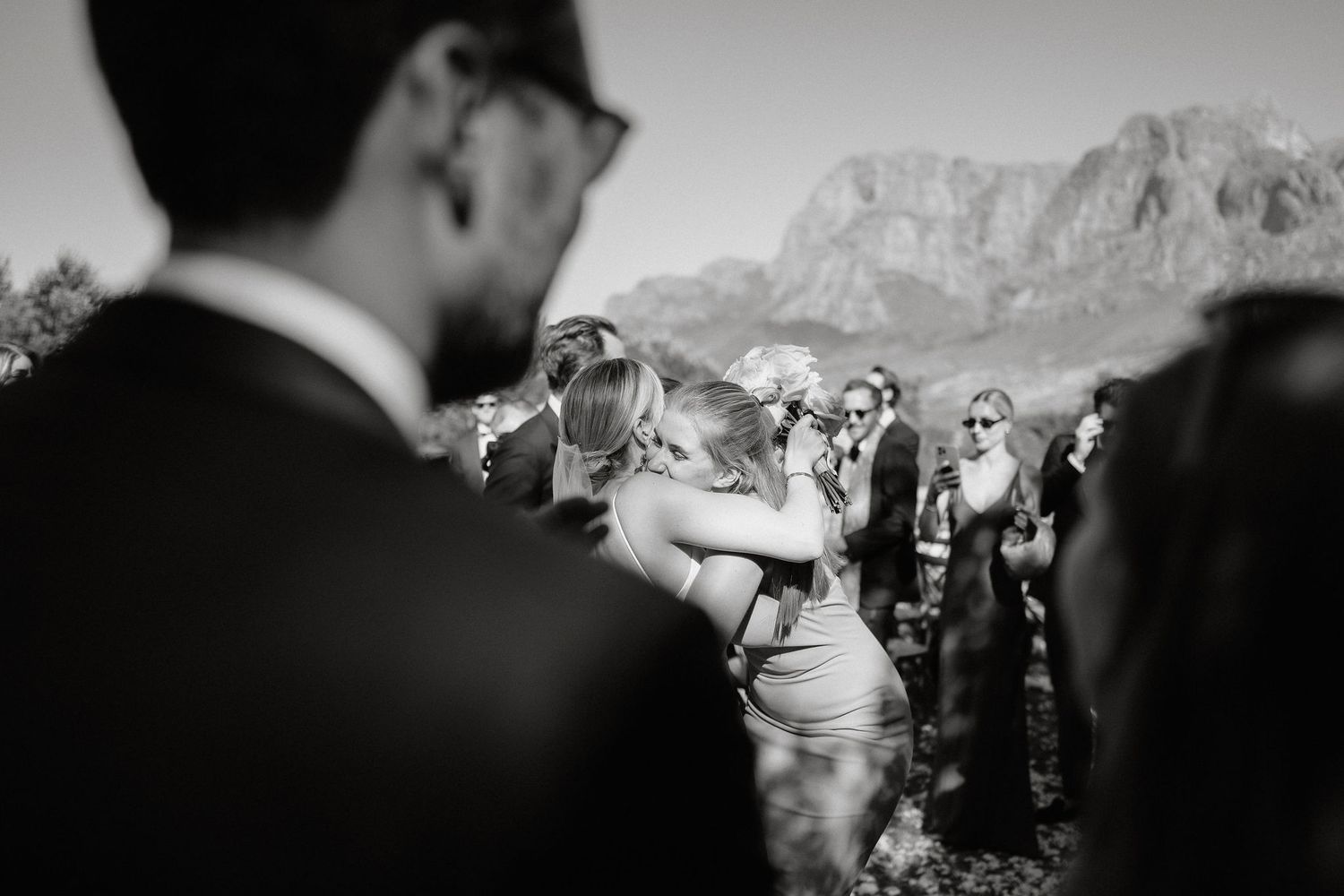 A black and white panoramic sequence of a wedding ceremony with mountain peaks in the background.