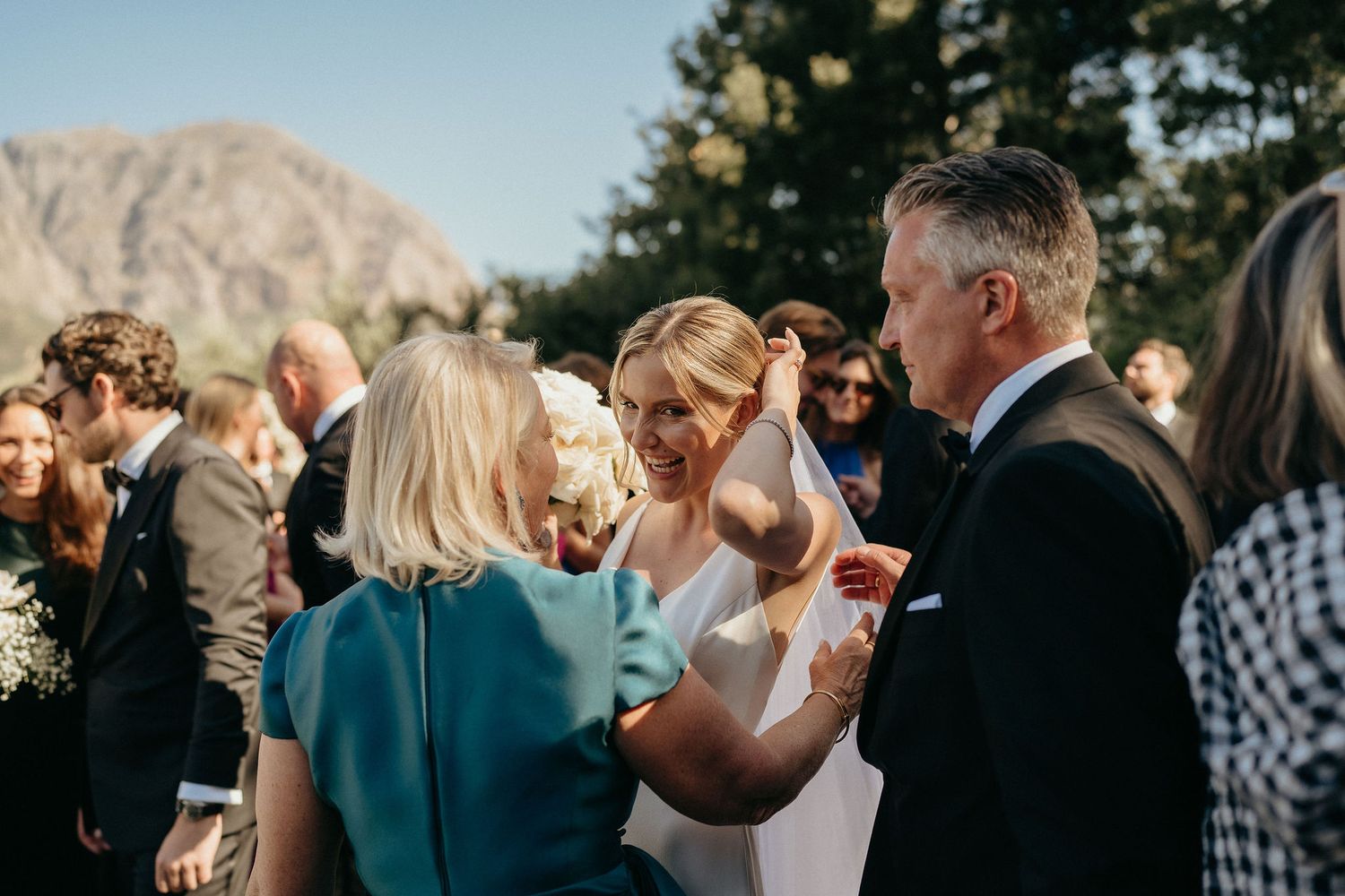 A series of candid moments from an outdoor wedding celebration with guests mingling during golden hour.