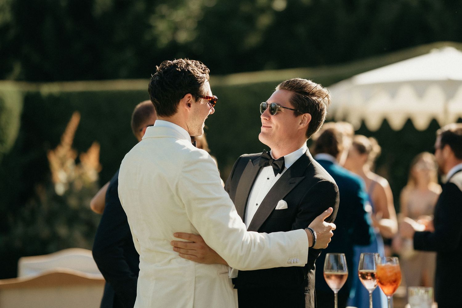 Wedding guests dance and celebrate together during an outdoor evening reception at a joyful celebration.