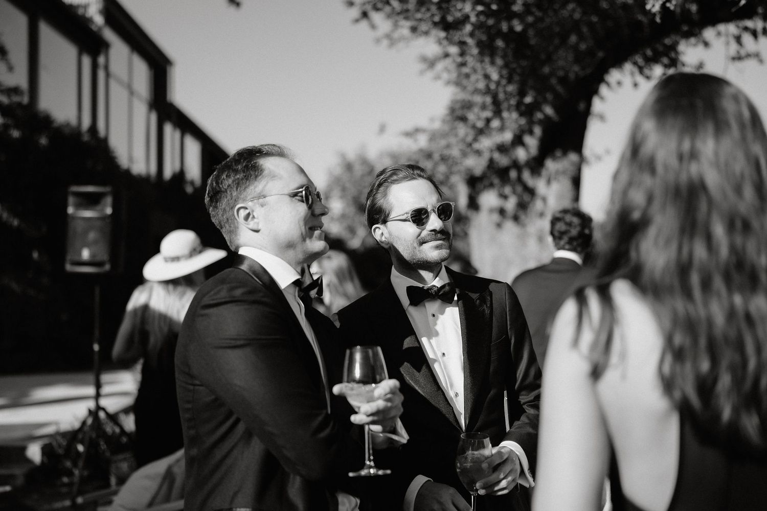 Black and white wedding photos showing guests mingling and celebrating at an elegant reception.