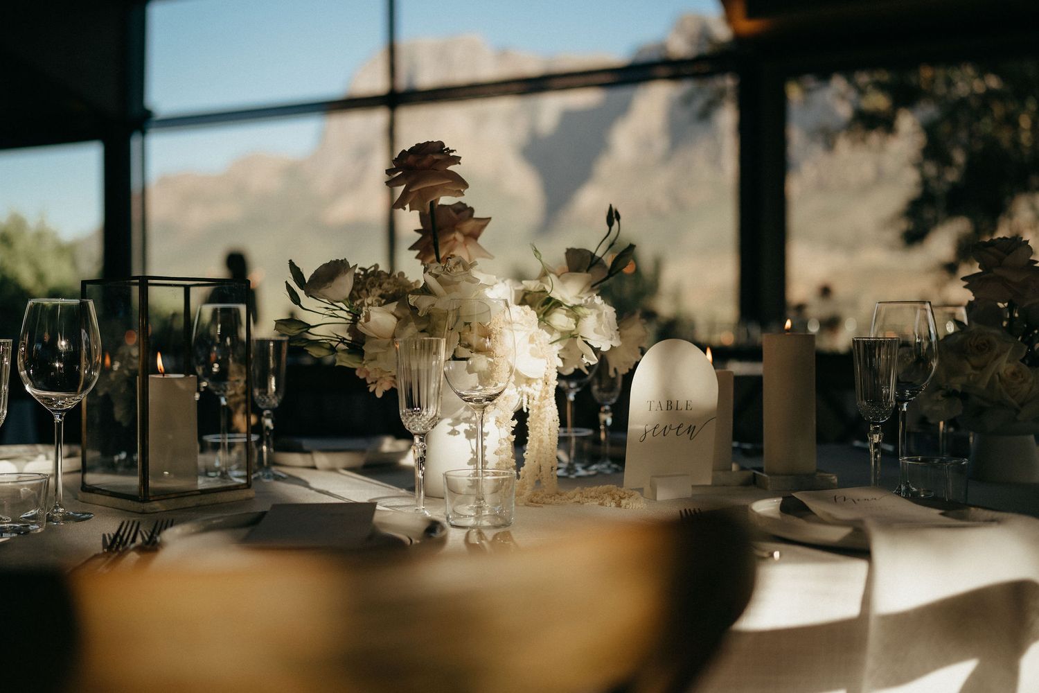 A cinematic wedding reception scene with warm backlighting streaming through windows during sunset.