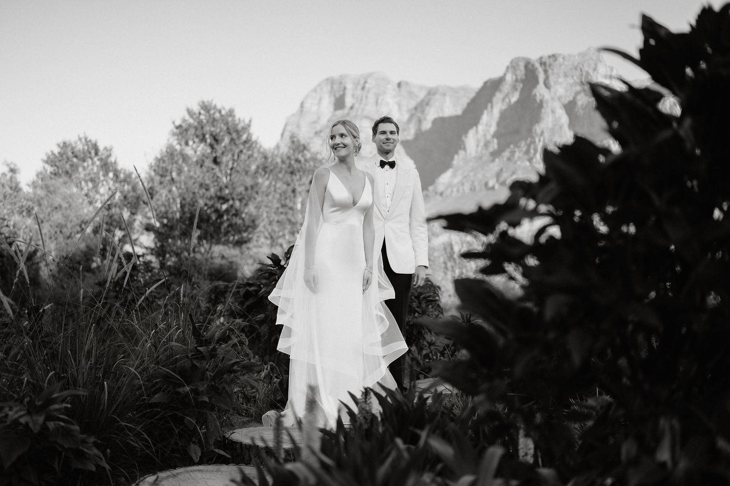 A black and white photo montage showing multiple wedding scenes with couples in formal attire against outdoor backgrounds.