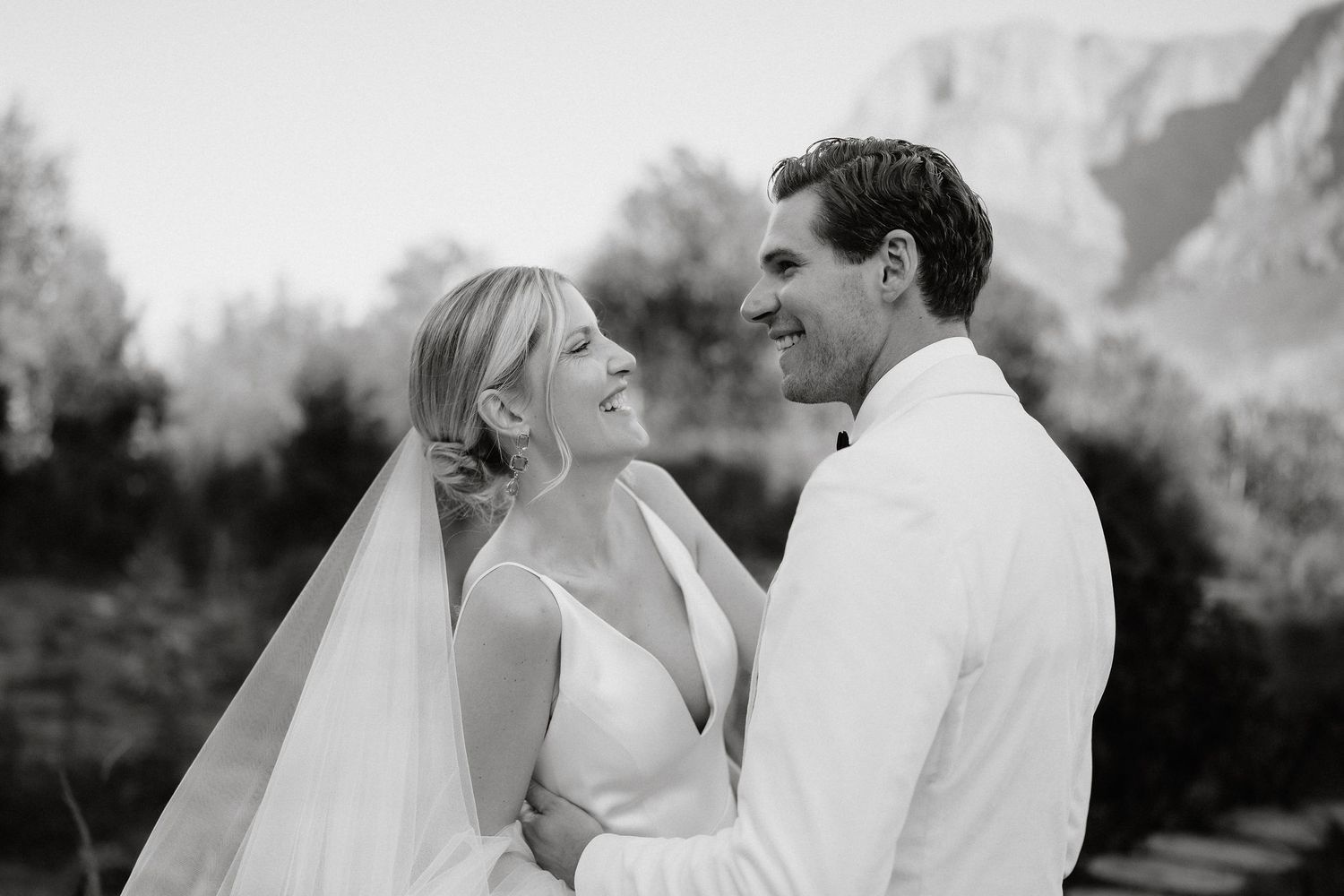 Black and white wedding photography sequence showing romantic moments between newlyweds outdoors.