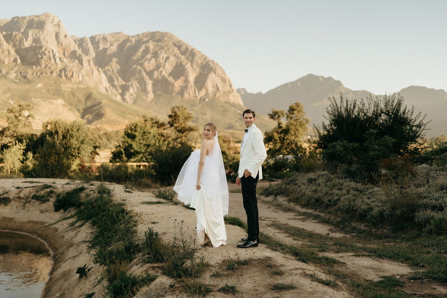 Desert wedding ceremony with rocky mountain backdrop and desert flora during golden hour.