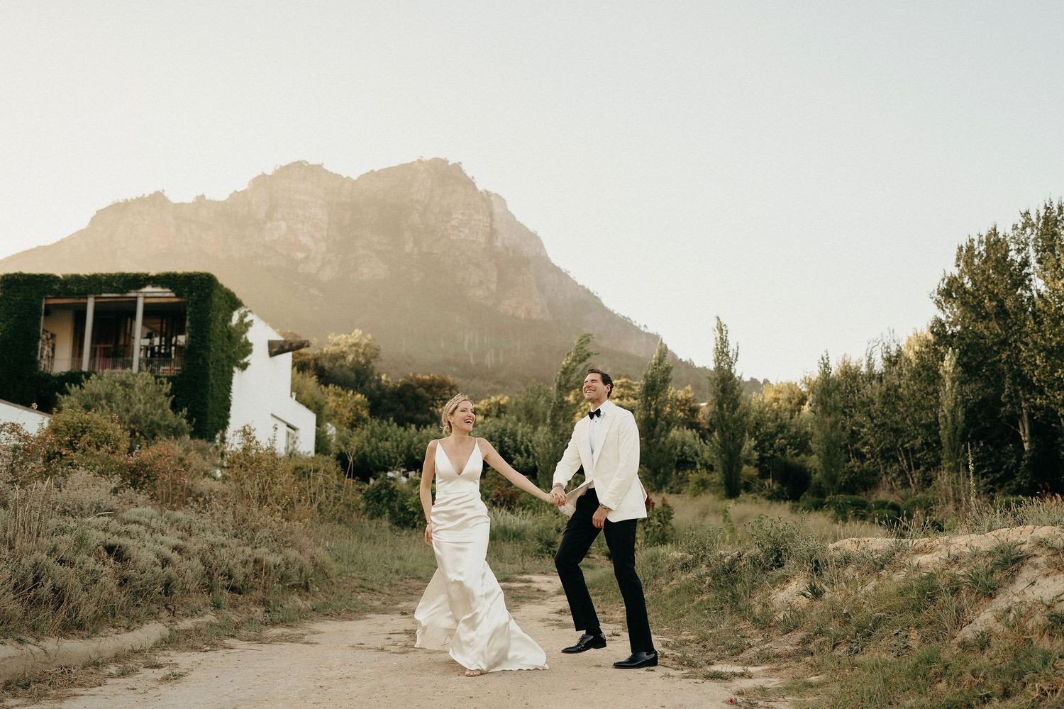 Scenic mountain vista with figures walking along a winding path surrounded by natural terrain.