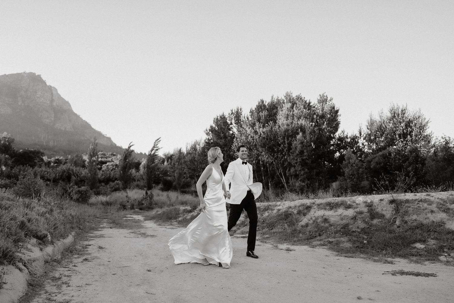 A series of black and white desert landscape photographs showing couples walking through scenic desert terrain.