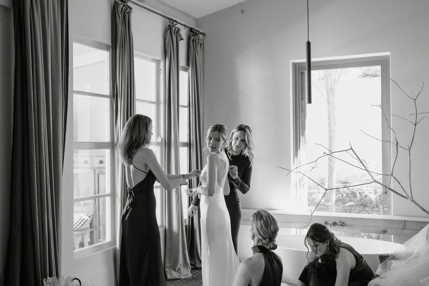 Black and white photograph of a window with curtains and natural light casting shadows in an interior room.