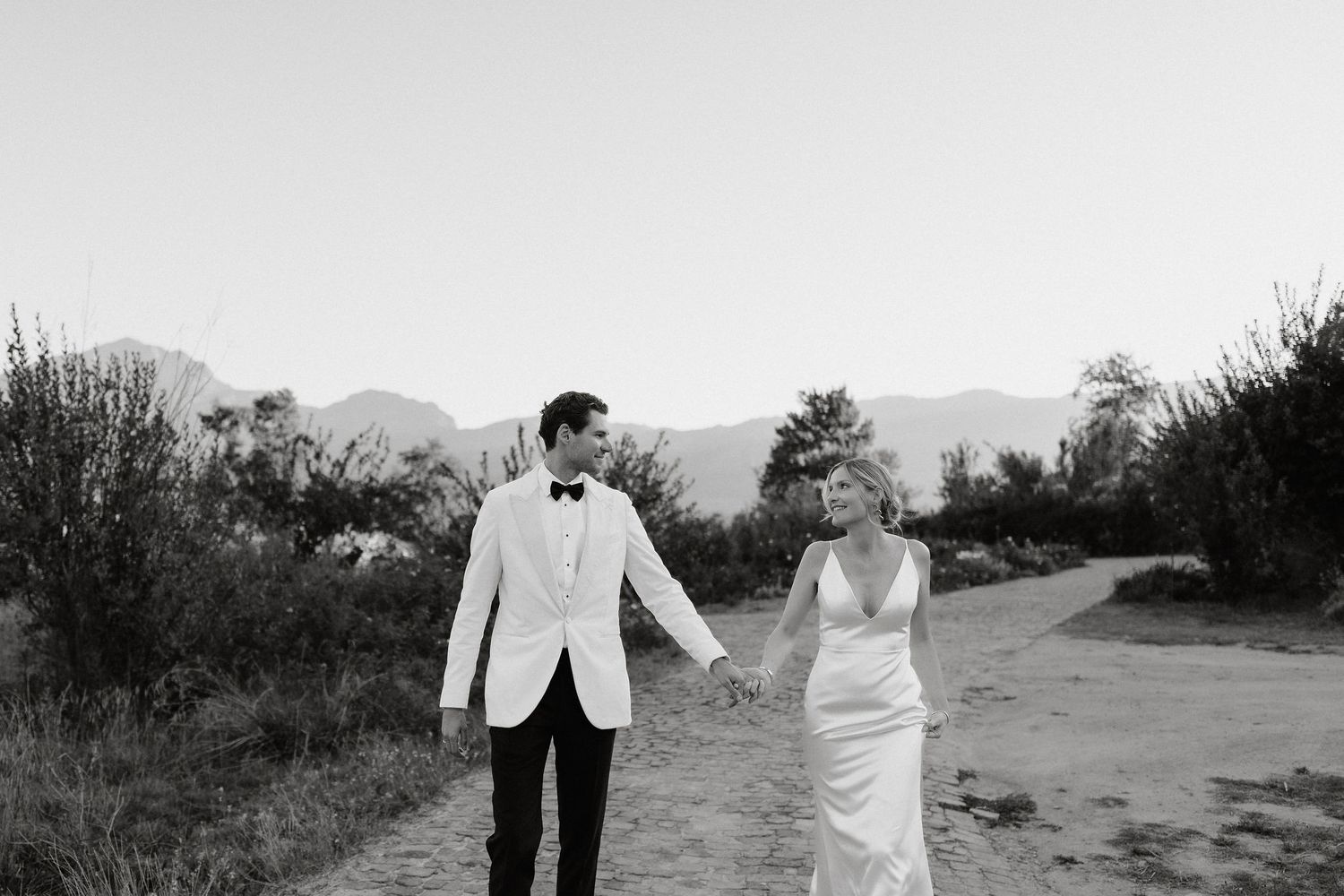A romantic black and white wedding photo series showing couples embracing in outdoor garden settings.