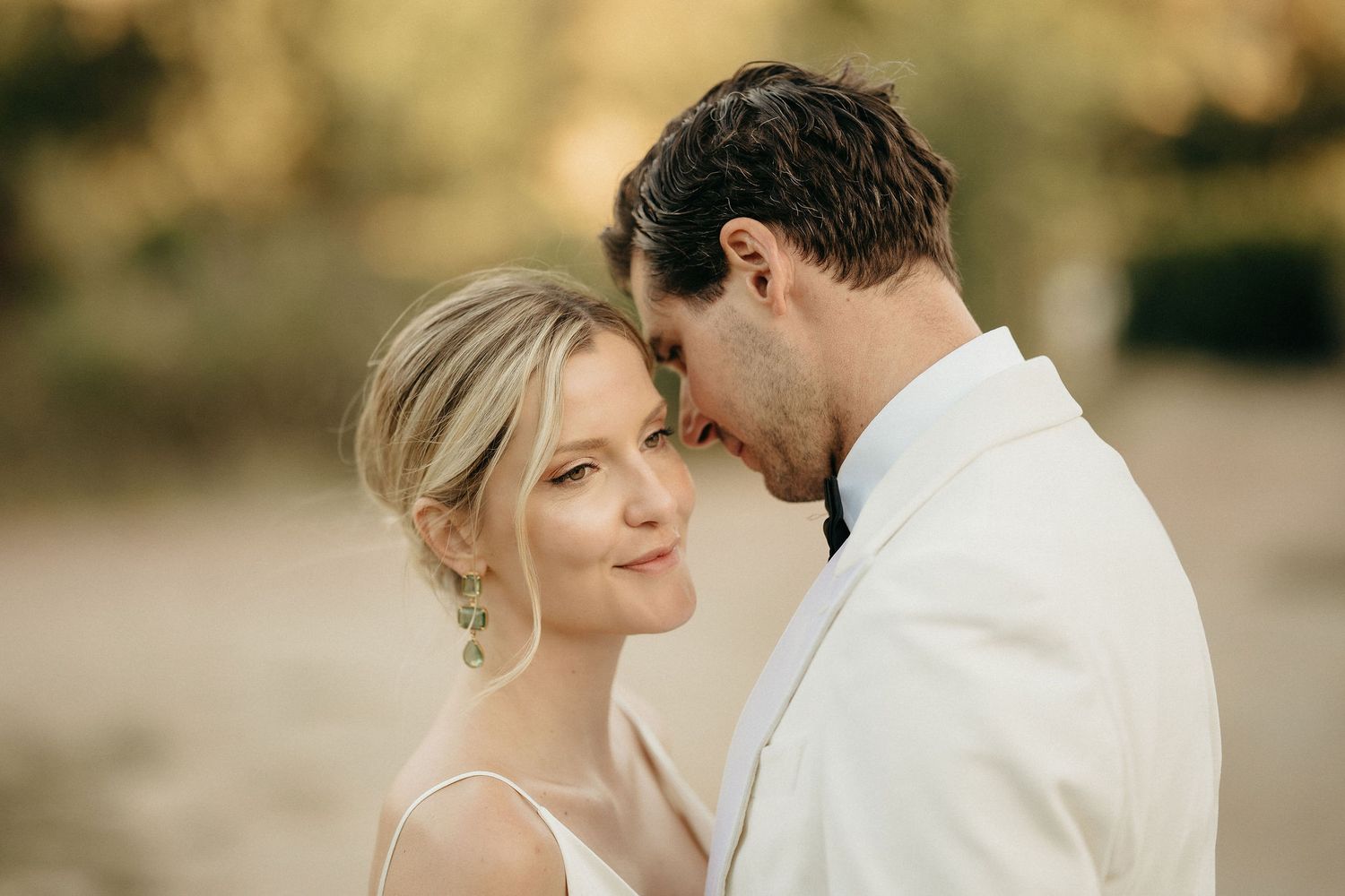 A romantic wedding couple shares intimate moments in a series of warm-toned outdoor portraits.