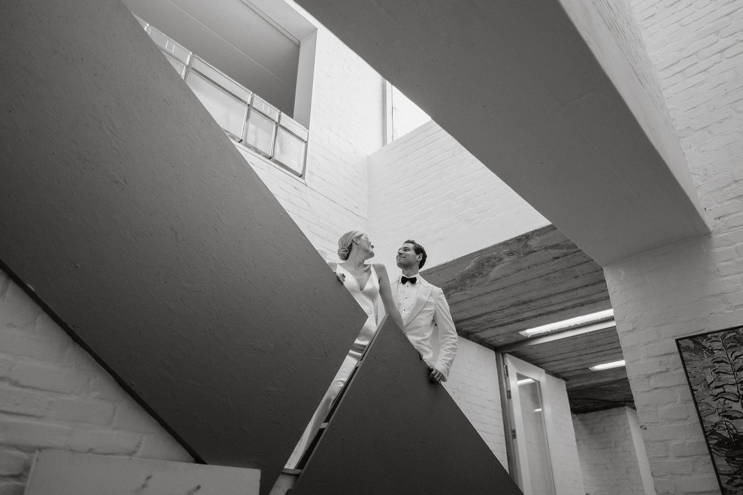 A minimalist architectural interior featuring angular white walls and skylights creating dramatic shadows.