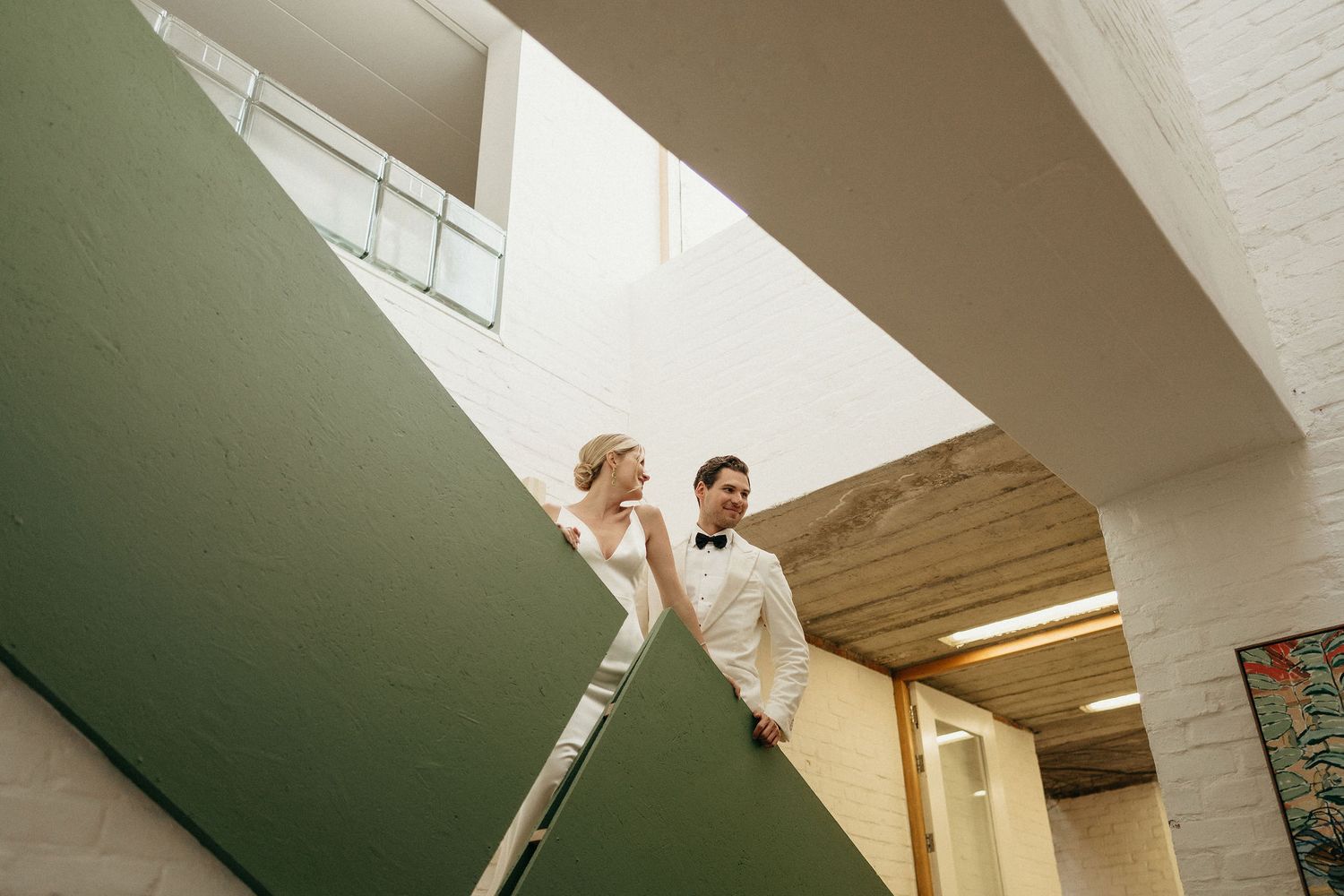A series of connected images showing someone ascending a staircase in an interior space with white walls and natural lighting.