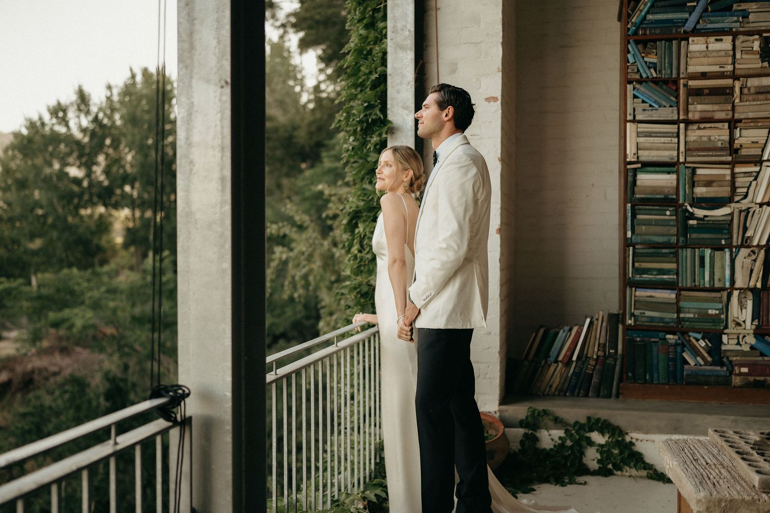 Romantic scene on a porch with couple standing close together against white columns.