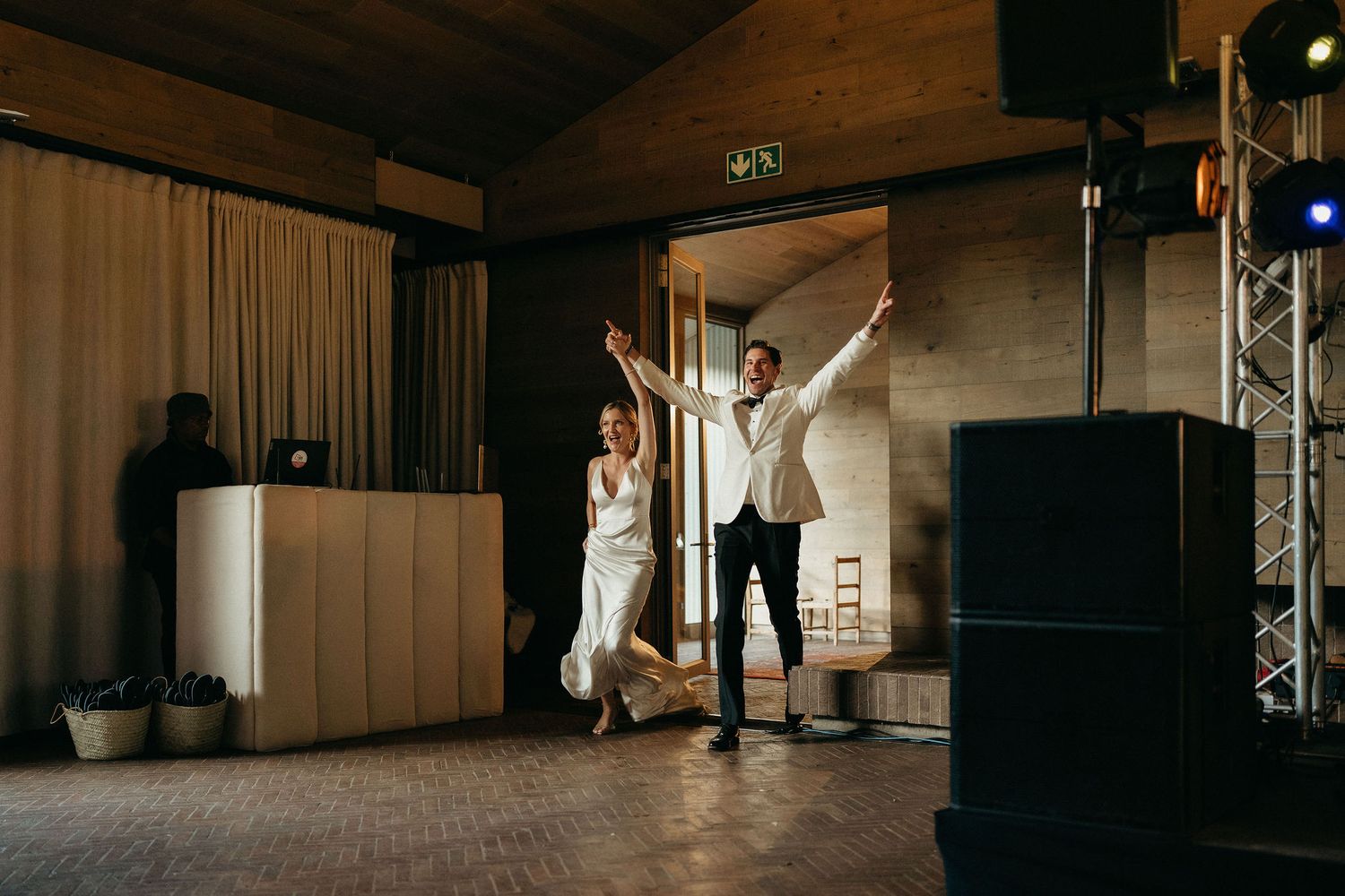 Two dancers perform an elegant lift during a contemporary dance rehearsal in a dimly lit studio space.