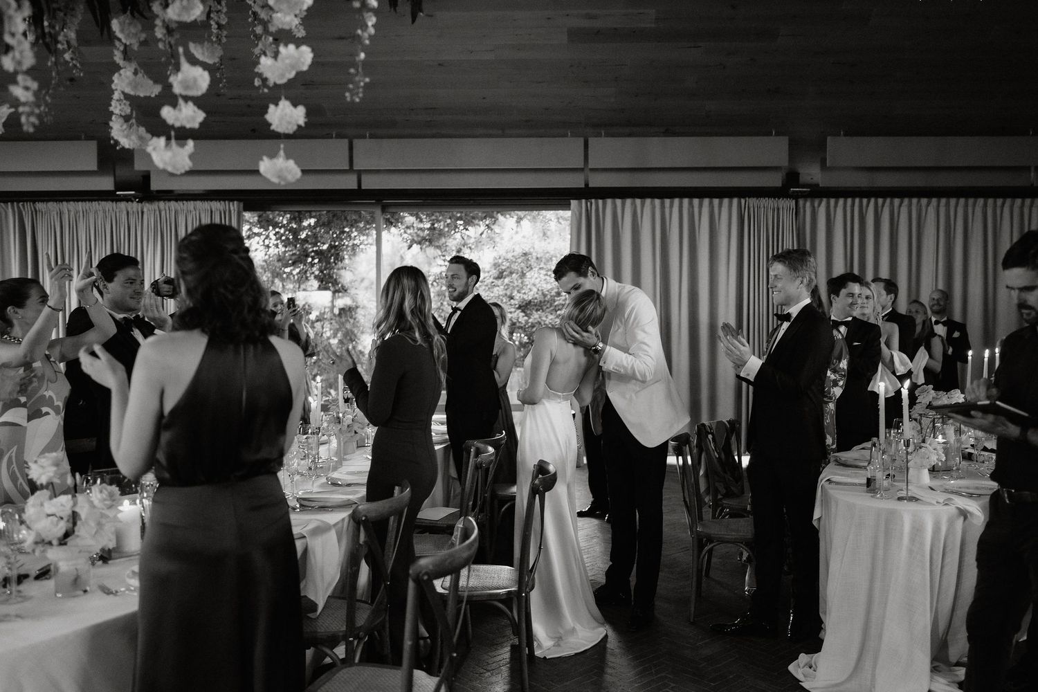 A black and white photo montage of wedding reception scenes showing dancing, mingling and celebration moments.
