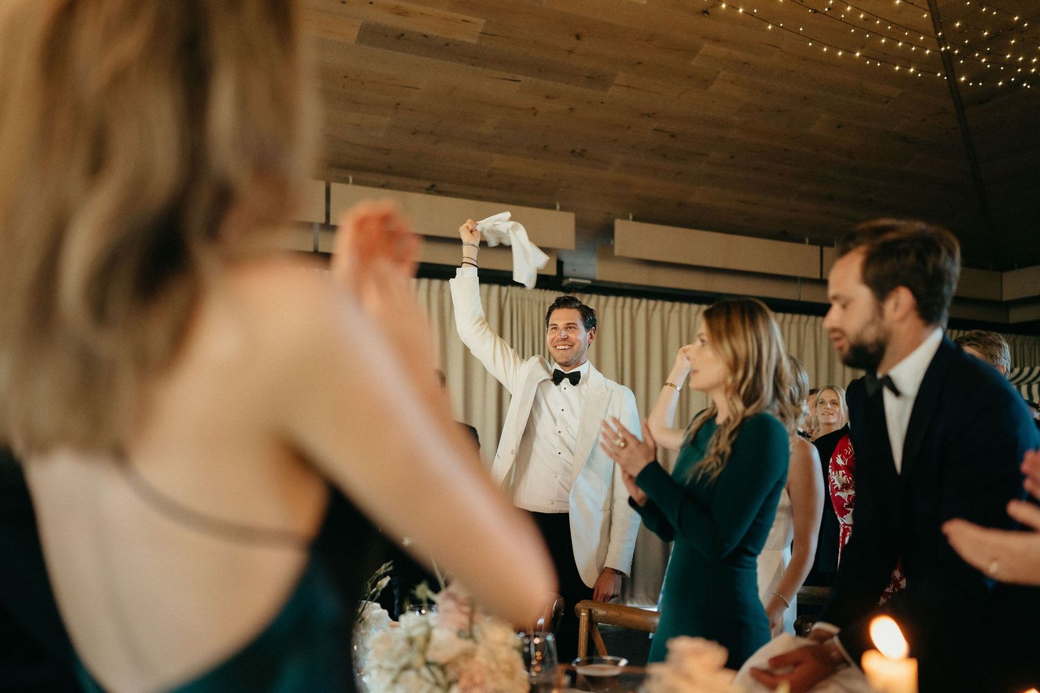 Wedding guests dance and celebrate together during a lively reception party on a dance floor.