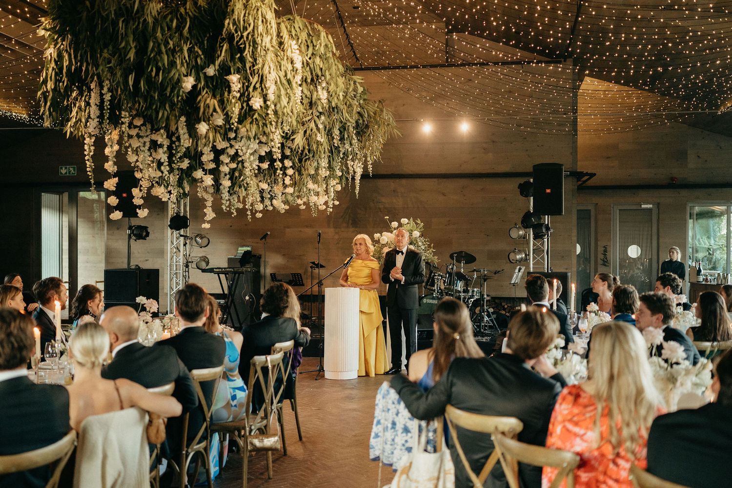 Wedding reception venue decorated with elegant crystal chandeliers and warm lighting creates a romantic atmosphere.