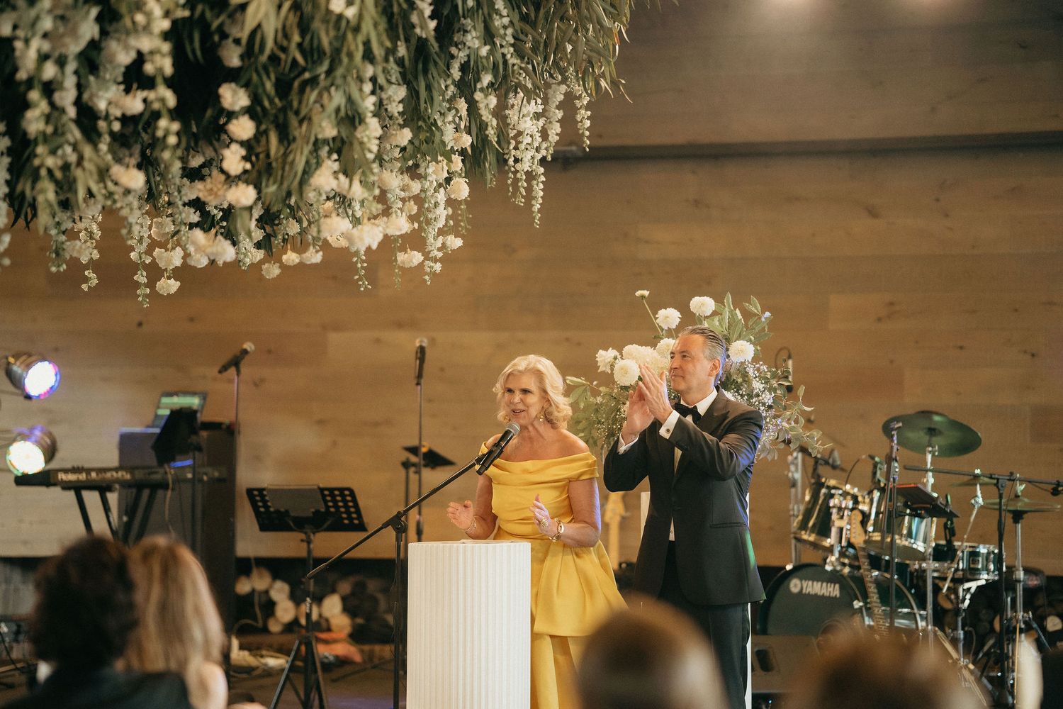 A romantic wedding reception venue decorated with elegant crystal chandeliers and warm lighting creates an intimate atmosphere.