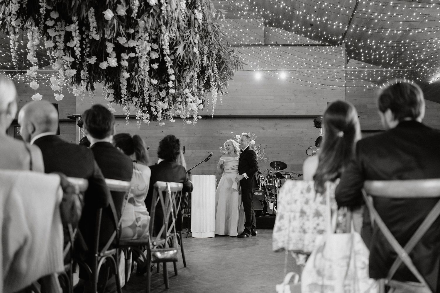 Wedding guests dancing and celebrating on an outdoor dance floor during a reception party at dusk.