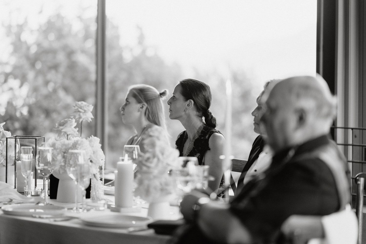 Black and white photo series showing a couple in intimate moments by a window during their wedding day.