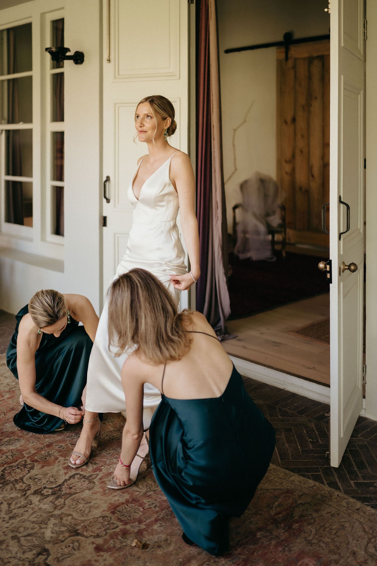Woman in white top and navy skirt sits and poses in a rustic hallway setting, shown in multiple angles.