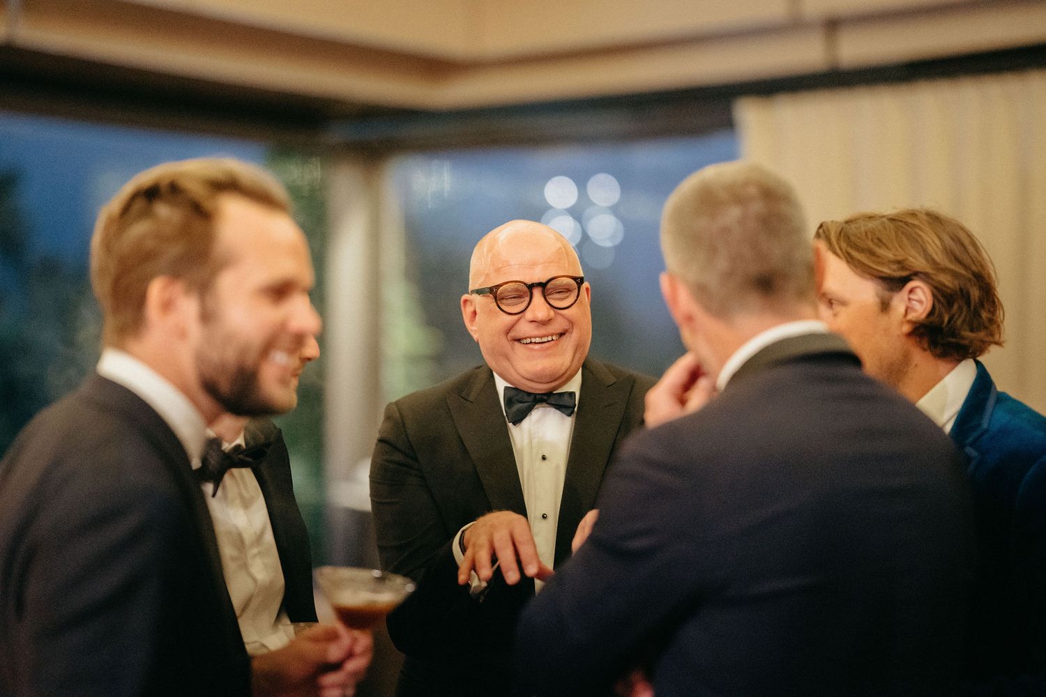 Guests in formal attire mingle and socialize during an elegant evening event.