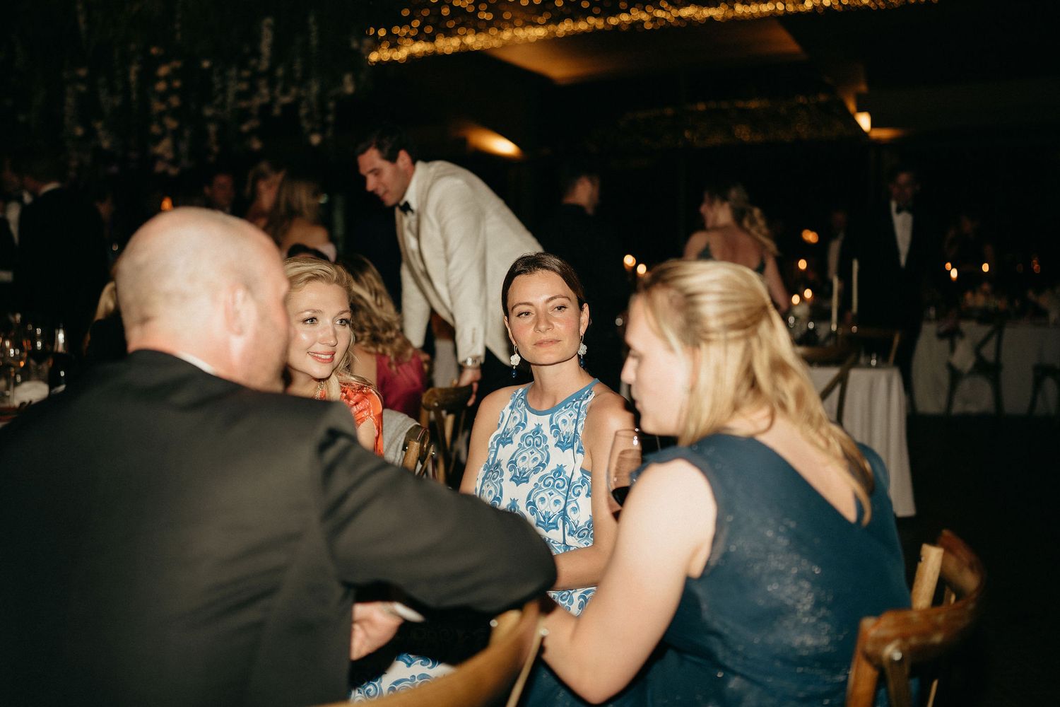 People dancing and socializing at a dimly lit party or event venue.
