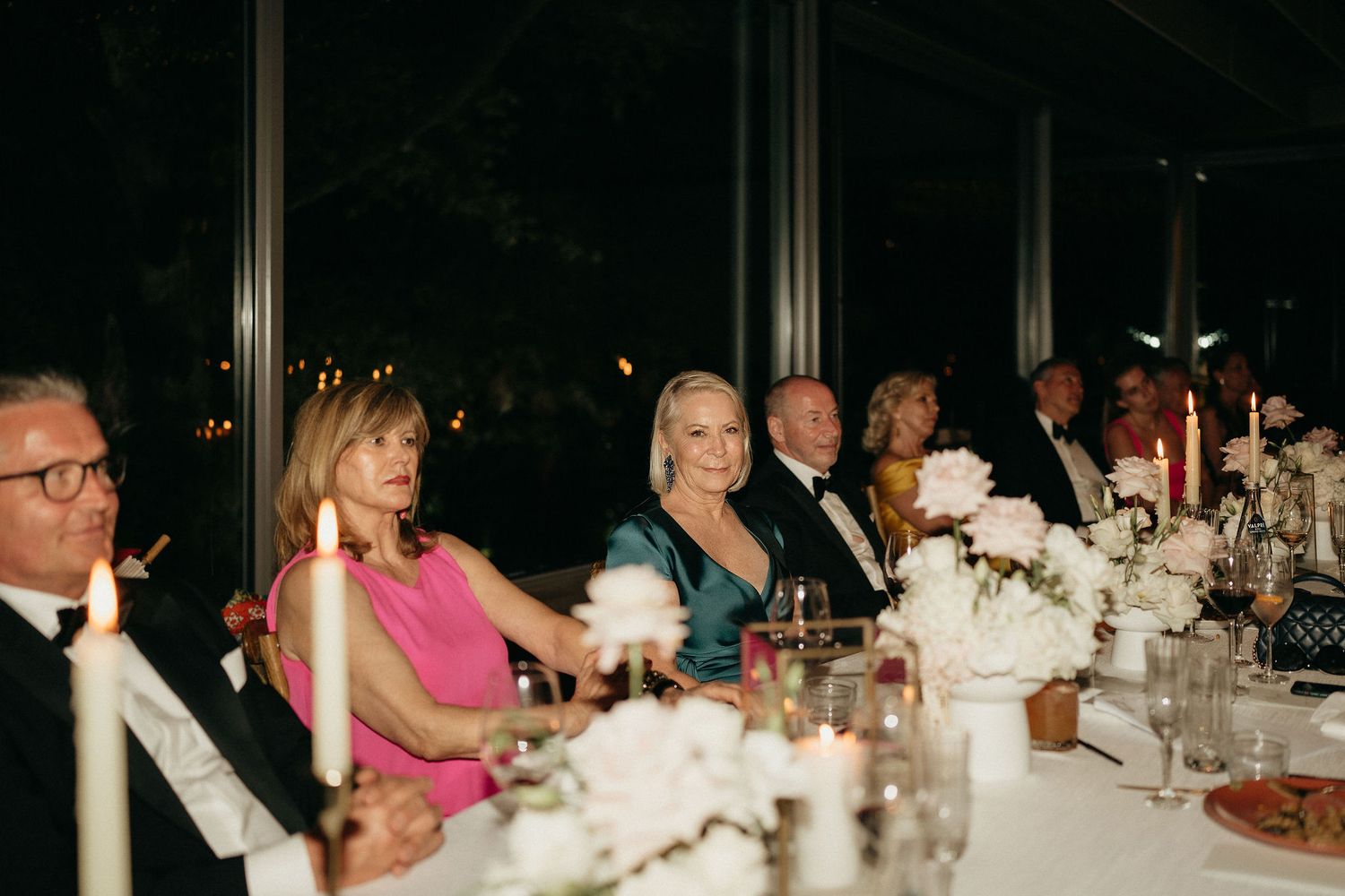 Panoramic view of guests seated at a formal dinner event with white tablecloths and elegant table settings.