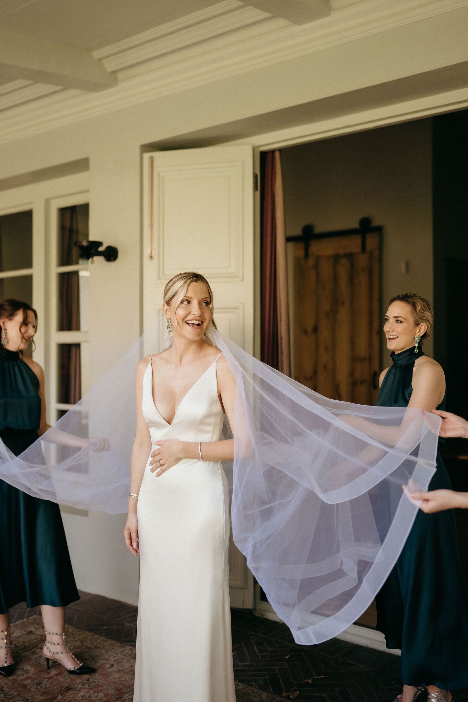 A sequence of photos showing a bride in a white dress adjusting her flowing veil in an indoor setting.