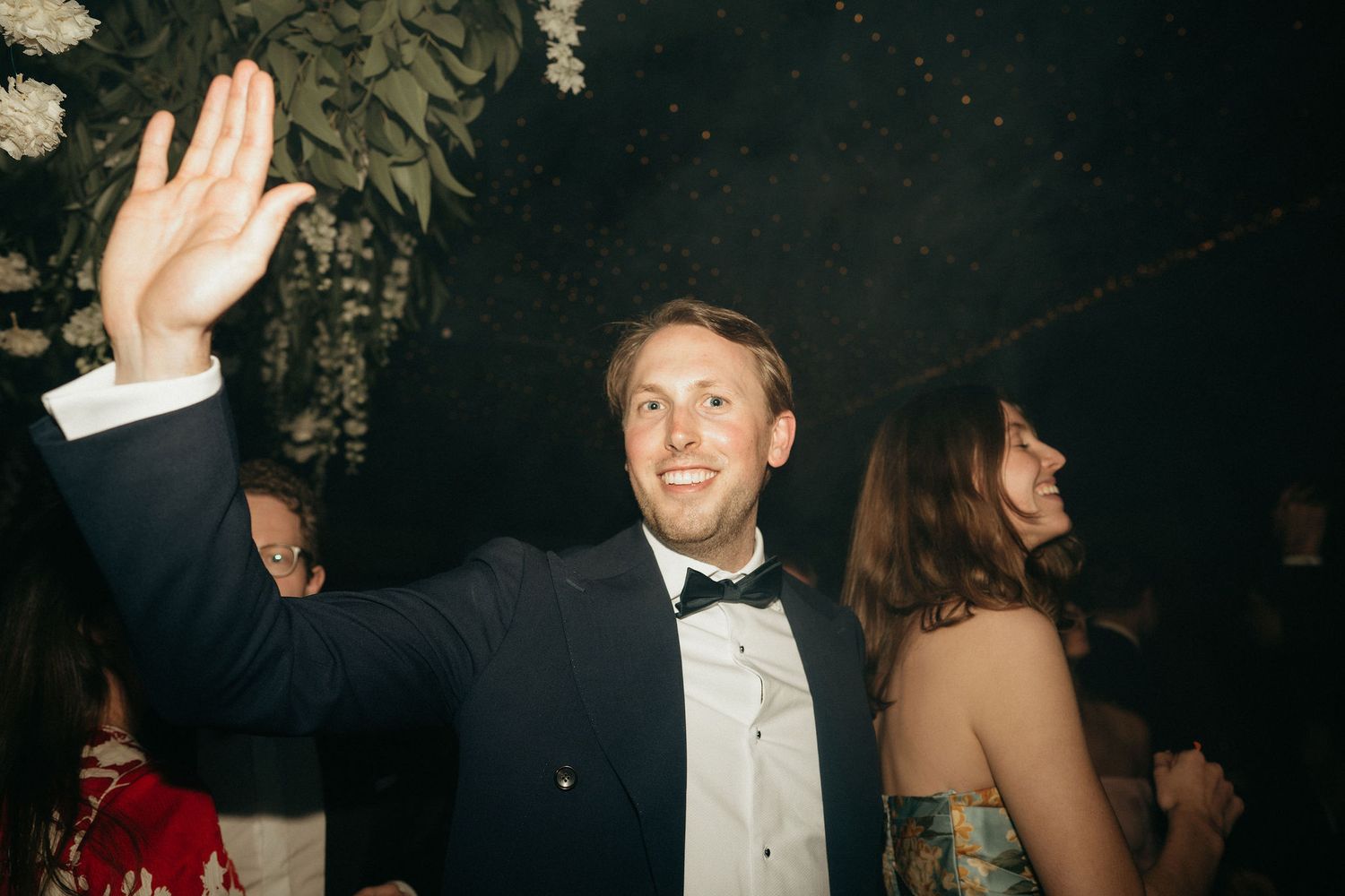 People dancing and celebrating at an elegant formal event in black tie attire.