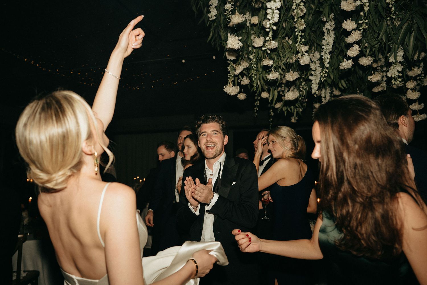 A sequence of black and white photos showing people dancing and celebrating at what appears to be a wedding reception.