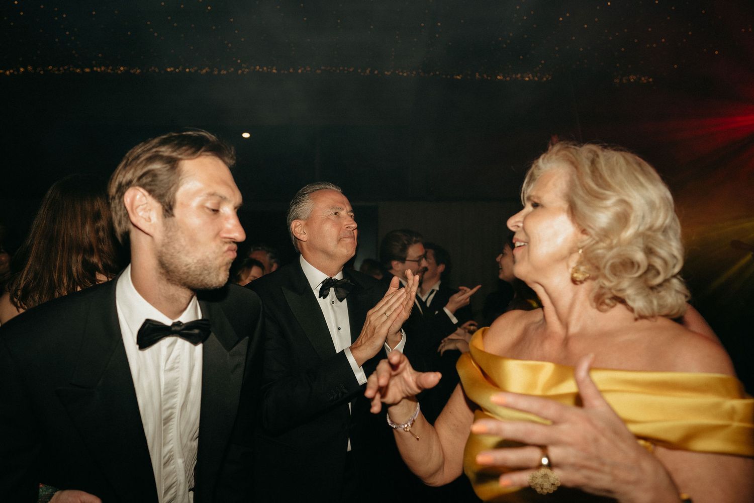 Guests in formal attire enjoying a lively celebration at an elegant evening event.