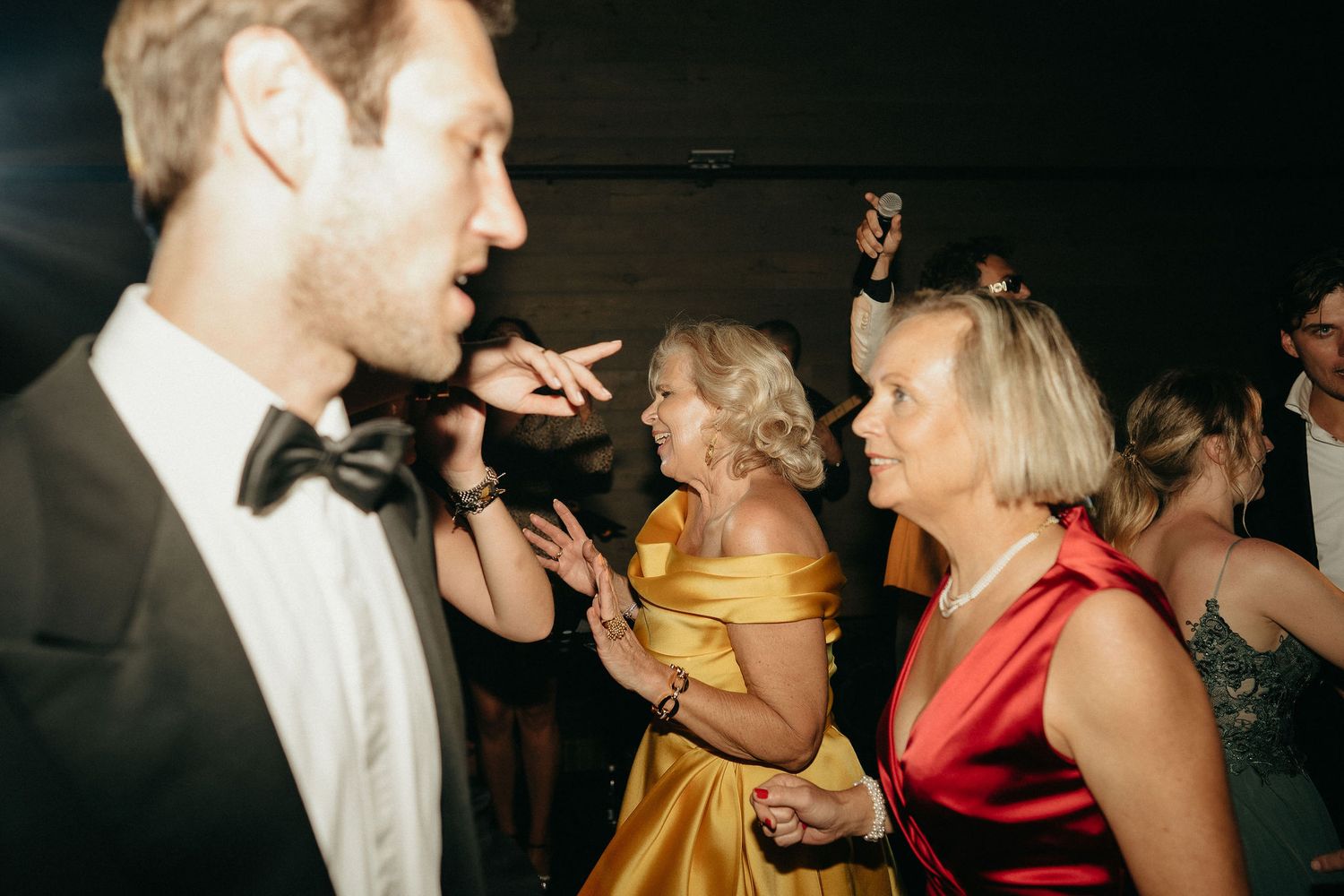 Couples dancing and socializing at a dimly lit party or nightclub event.