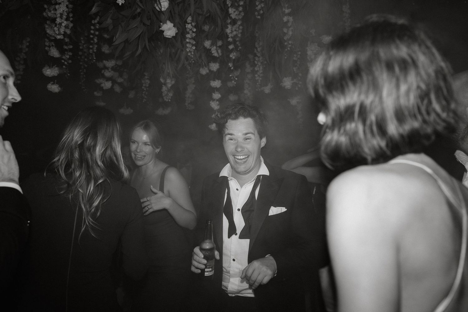 Black and white collage of candid party photos showing people dancing and celebrating at a social gathering.