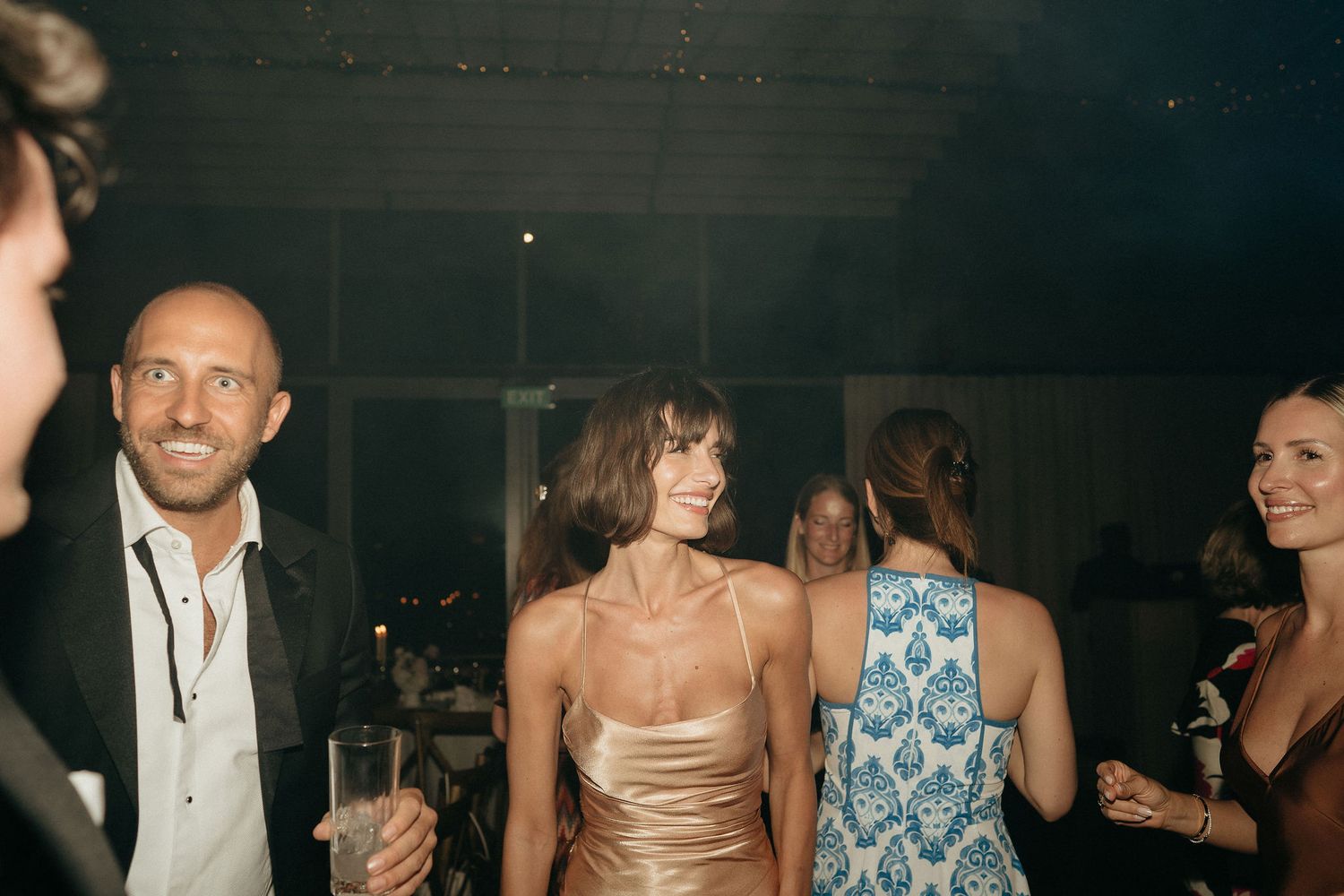 People dancing and enjoying themselves at what appears to be a wedding reception or celebration event.