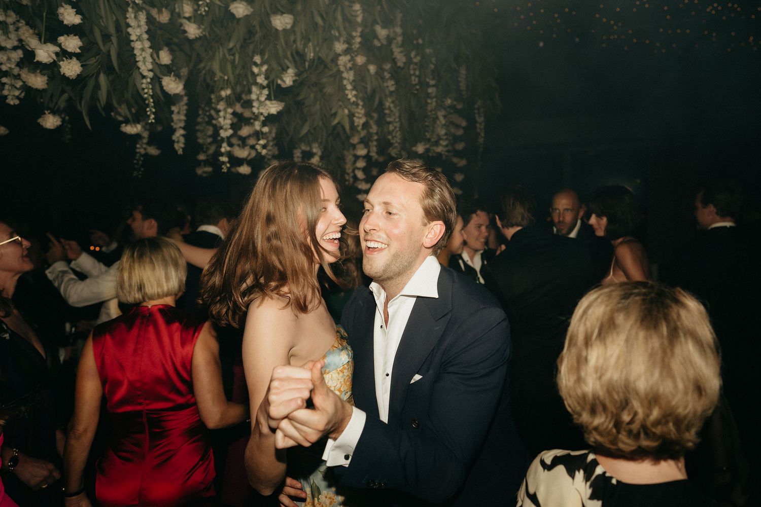 People dancing and socializing at an elegant evening party in formal attire.