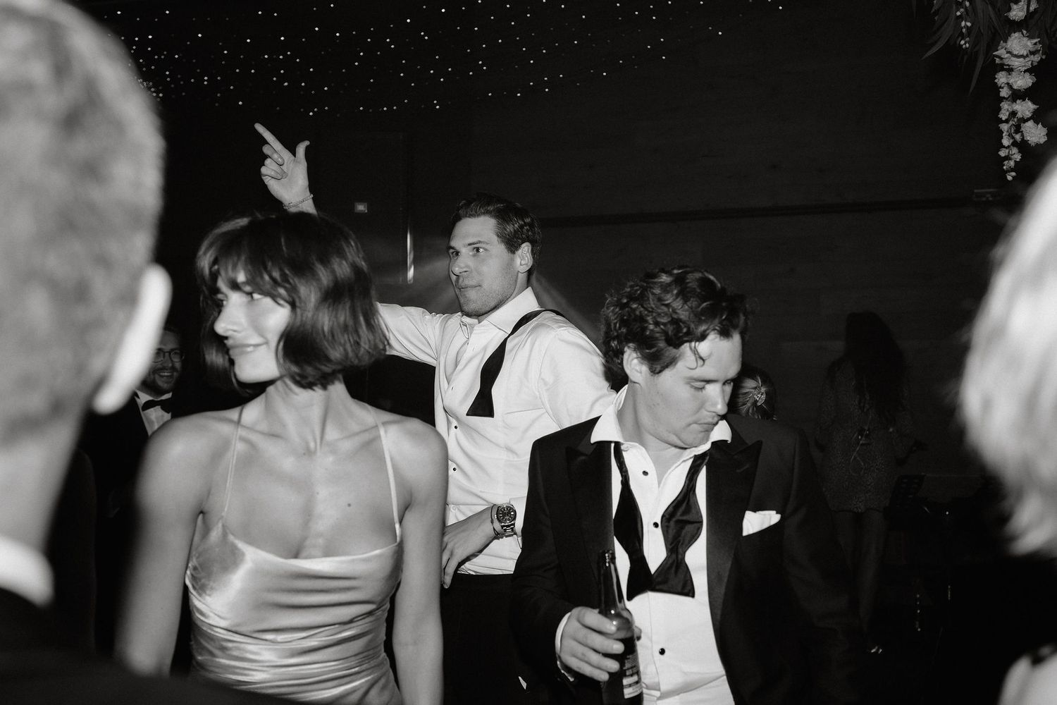 Partygoers in formal attire dancing and enjoying themselves at a black and white reception.