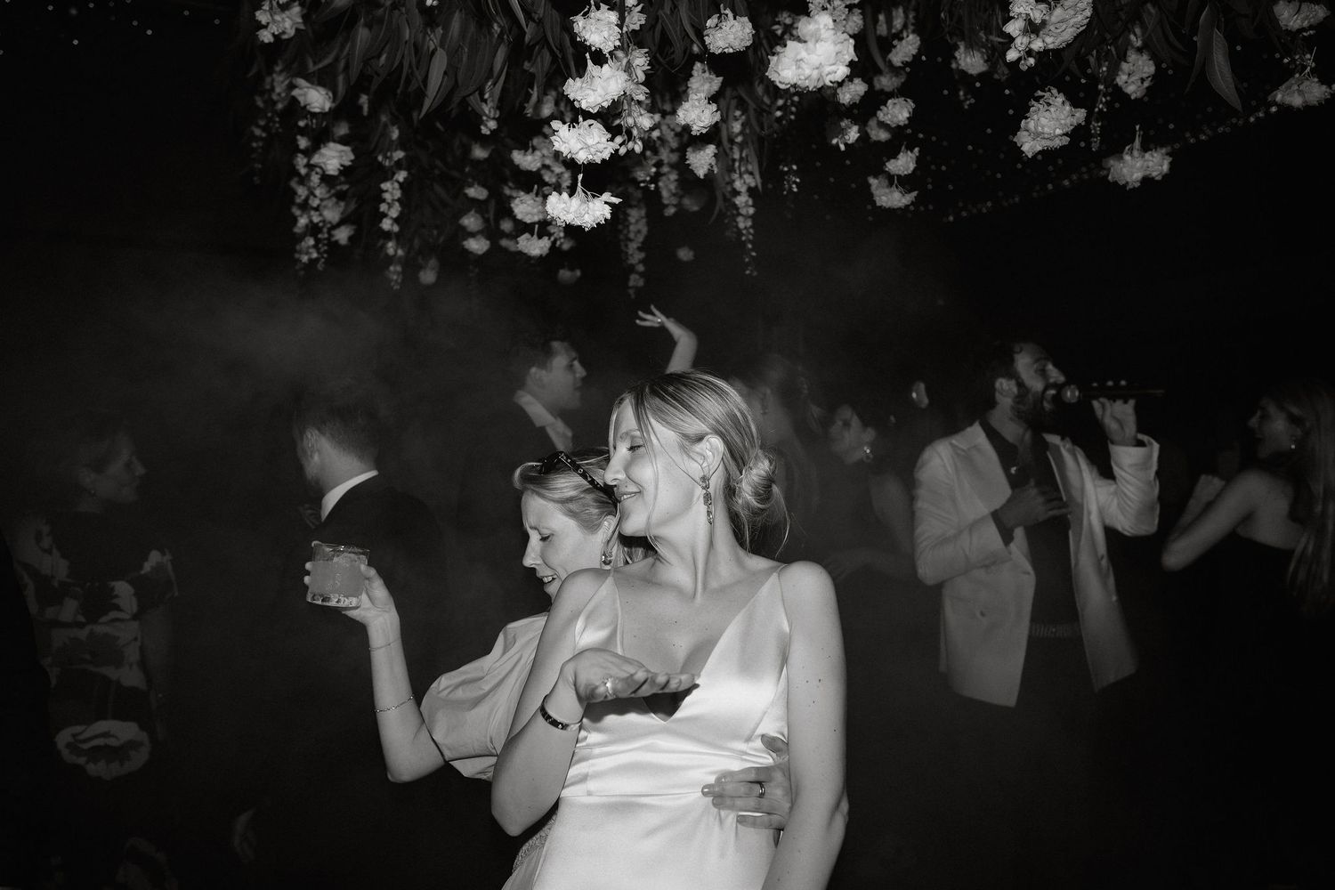 A couple shares a romantic dance together at their wedding reception in a dimly lit ballroom.