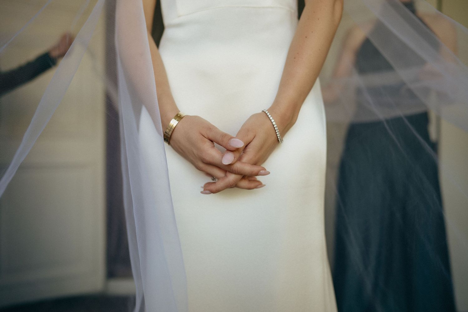 Close-up details of a white wedding dress showing delicate lace patterns and beading on the bodice.
