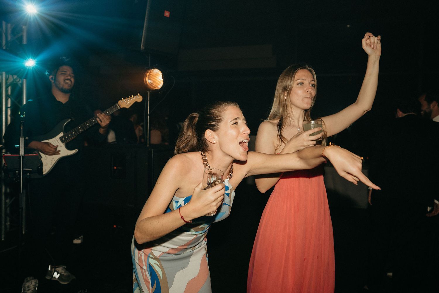 People dancing and having fun at a nightclub under blue lighting.